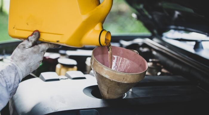 cierre-mecanico-de-automoviles-vertiendo-mano-y-reemplazando-aceite-fresco-en-el-motor-del-automovil-en-el-taller-de-reparacion-de-automoviles-mantenimiento-de-automoviles-y-concepto-de-industria